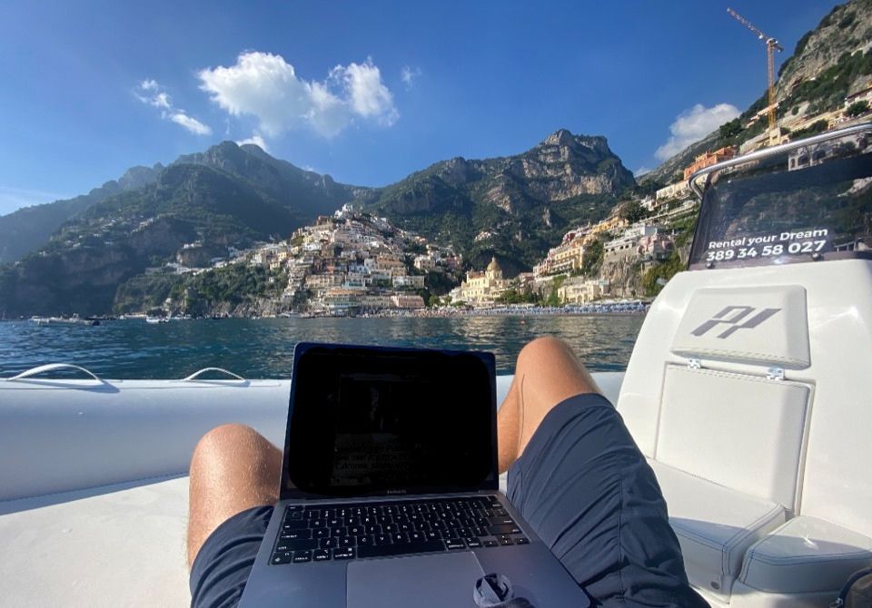 Tom working on a laptop from a boat on the Amalfi Coast